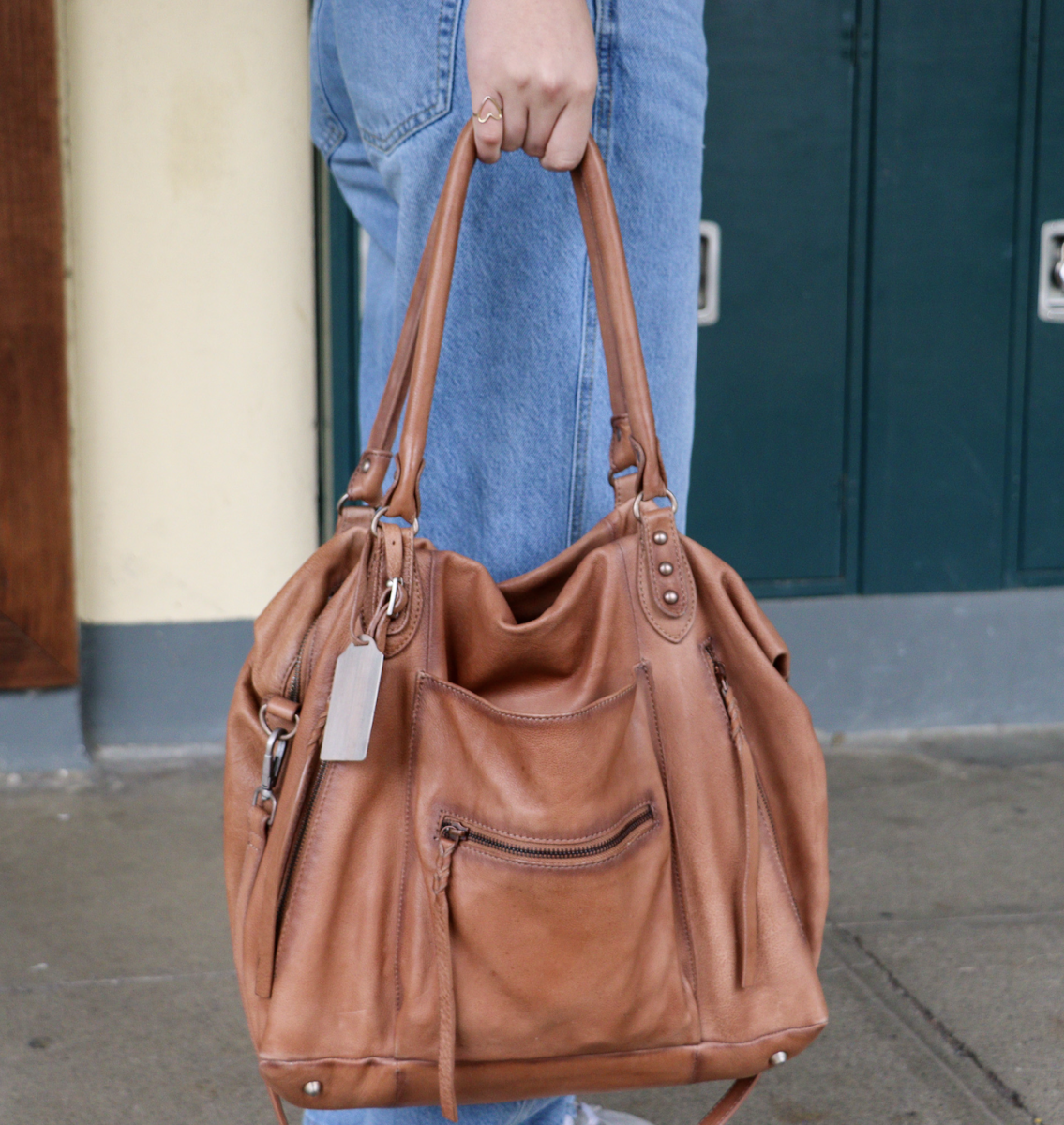 An Archie Williams student walks the halls with a Free People leather tote bag. 